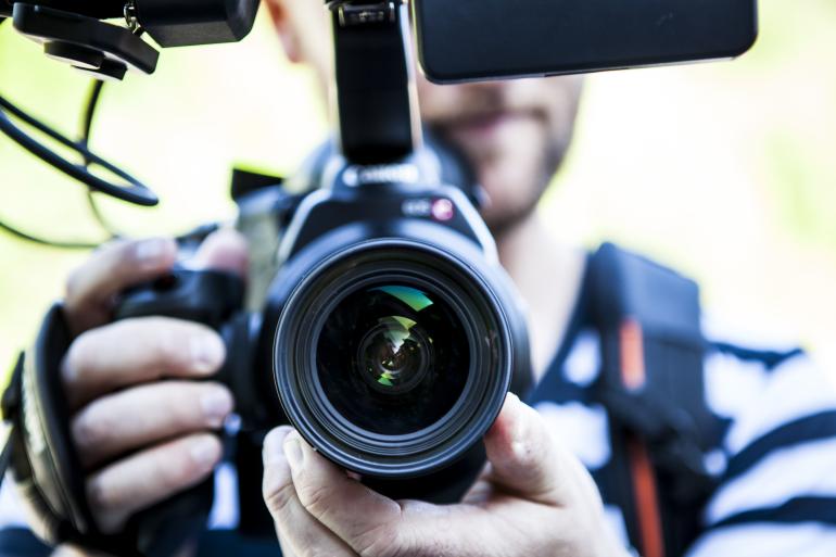 Person holding canon dslr camera close up photo